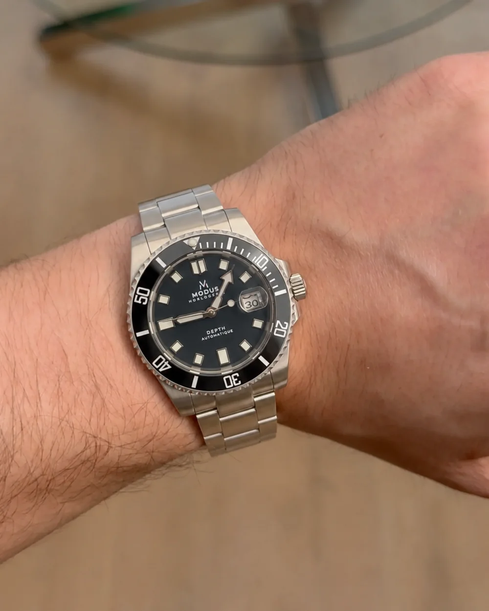 Depth Automatique à cadran noir portée au poignet, bracelet acier